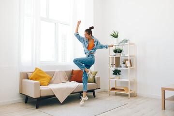 Poster - Joyful Woman Jumping in her Home – A Carefree Concept of Happiness and Relaxation