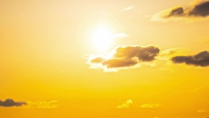 timelapse of rolling clouds in open sky, orange glare while sun paints the sky