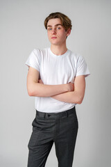 Wall Mural - Young Man With Arms Crossed Standing Against a Plain Background in a Studio