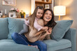 © Graphicroyalty - Happy Beautiful Mother carrying or piggyback her little daughter laughing playing and having fun together on sofa at home.