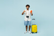 Full body traveler Indian man wears white casual clothes hold bag passport ticket show thumb up isolated on plain blue background. Tourist travel abroad in free time rest getaway. Air flight concept.