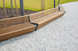 New bench with wooden slats and metal structure and gravel paving