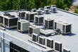 The external units of the commercial air conditioning and ventilation systems are installed on the roof of an industrial building.