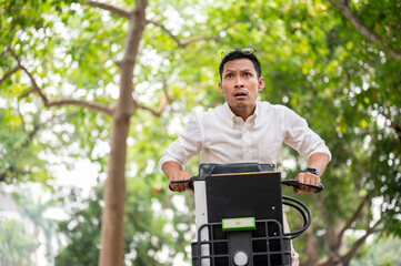 An anxious Asian businessman is in a hurry to get to work in the morning, riding a bike.