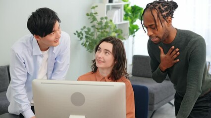 Multinational people talking while looking at desktop PC in the lobby. International business.