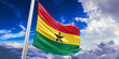 Ghana national flag cloth fabric waving on beautiful Blue Sky Background.