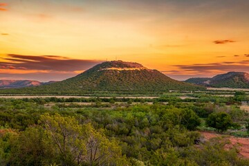 Landscape shot of mountains with windmills with the beautiful sunset in the background in Texas