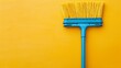 Top view of a plastic broom on a yellow background