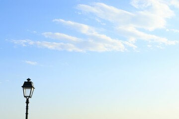  Closeup of a street light post on a street with a cloudy sky in the background