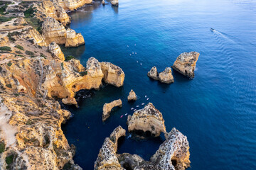 Wall Mural - Sunrise over Ponta de Piedade, Algarve cliffs on coastline. Aerial drone view