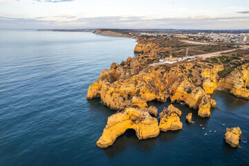 Wall Mural - Sunrise over Ponta de Piedade, Algarve cliffs on coastline. Aerial drone view