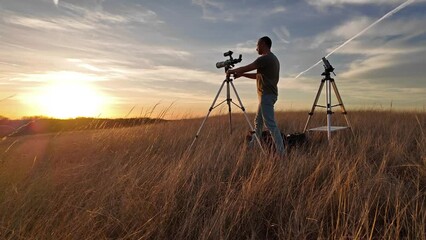 amateur astronomer observing solar eclipse and sun with a telescope and special solar filter.