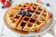 © Марина Веретенникова - A large round Belgian waffle with berries and syrup.
