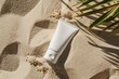 Top view of a white mockup of a cream tube on sand
