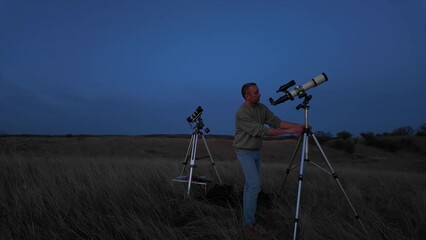 Wall Mural - amateur astronomer looking at the evening skies, observing planets, stars, moon and other celestial 