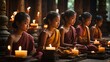 Group of young monks in traditional saffron robes meditating peacefully with lit candles in a serene temple setting