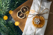 A gift wrapped in kraft paper tied with a rope Christmas stollen decorated with dried orange fruits and spruce branch. Sweet present. Wrapped traditional Christmas cake. Top view