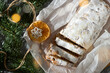 A gift wrapped in kraft paper tied with a rope Christmas stollen decorated with dried orange fruits and spruce branch. New Year holiday baking. Sweet present. Top view