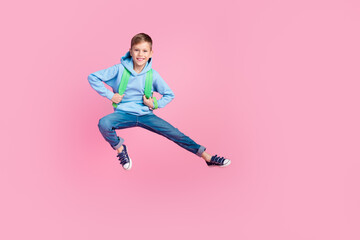 Wall Mural - Full length photo of energetic little boy carry school bag jump leg kick empty space isolated on pink color background