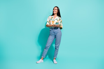 Wall Mural - Full length photo of cheerful lovely girl wear stylish nice clothes watching empty space promo offer ad isolated on cyan color background