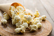 Close up of salted popcorn on wooden table.
