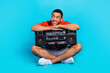 Full size portrait of nice young man hold boombox look empty space summer holiday isolated on blue color background