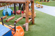 Empty playground with various equipment and toys on green synthetic grass