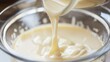 A baking recipe calls for almond milk, its smooth, light beige liquid mixing seamlessly into the batter, promising a moist texture low texture