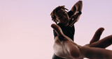 Fototapeta Nowy Jork - Expressive gen z male dancing to music with wireless earbuds in studio