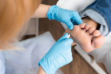 A podiatrist using clippers removes a callus from a womans foot at the medical center.