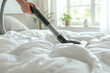 Vacuuming Over White Bedspread