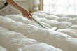 Vacuuming Over White Bedspread