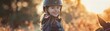 Smiling girl in a helmet ready for horseback riding. Outdoor activity and equestrian theme.