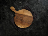 Fototapeta Desenie - Top view of empty round wooden cutting board with handle on beautiful dark background.