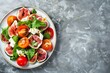 Overhead shot of fig tomato and goat cheese salad on gray granite vertical with room