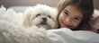Girl cuddles plush dog under white blanket