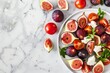 Vertical shot of fig tomato and goat cheese salad on white marble with copy space