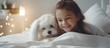 Girl cuddles white dog in bed
