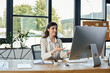 © LIGHTFIELD STUDIOS - A businesswoman is deeply focused while sitting at a desk with a computer in a modern office environment.