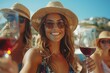 Happy women in sun hats and eyewear toast with wine glasses on the beach