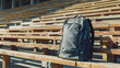 A blank, nylon sports backpack mockup, positioned on a wooden bleacher in an empty stadium, capturing the essence of athletic ambition and outdoor activities. 32k, full ultra hd, high resolution