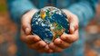 Hands gently cradle a realistic globe, symbolizing care and responsibility for the Earth