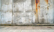 Pavement before grungy wall with stains and rust, textures speaking to urban decay and passage of time. Contrast between sidewalk and wall highlights neglect