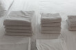 Clean towels are on bed. White bedding close-up.  Concept - bed linen at hotel. Several towels lie on in a pile.