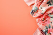 coral floral fabric elegantly arranged on a bright orange backdrop with copy space 