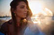 Close-up of woman's contemplative expression with a creative sun glare adding to the mood