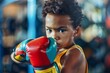 African American kid boxer in a vibrant gym space. Boy in boxing gloves practicing boxing punches. Concept of physical education, youth sports, childhood activity, active lifestyle, energetic pastime