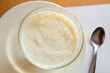Image of sweet white homemade pudding served at plate with spoon