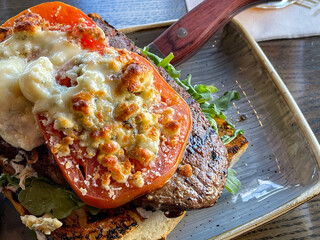 Wall Mural - Ribeye steak topped with grilled tomatoes and Parmesan cheese