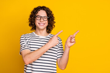 Sticker - Portrait of young nerd very smart guy in eyeglasses direct fingers useful tips rent book library isolated on yellow color background